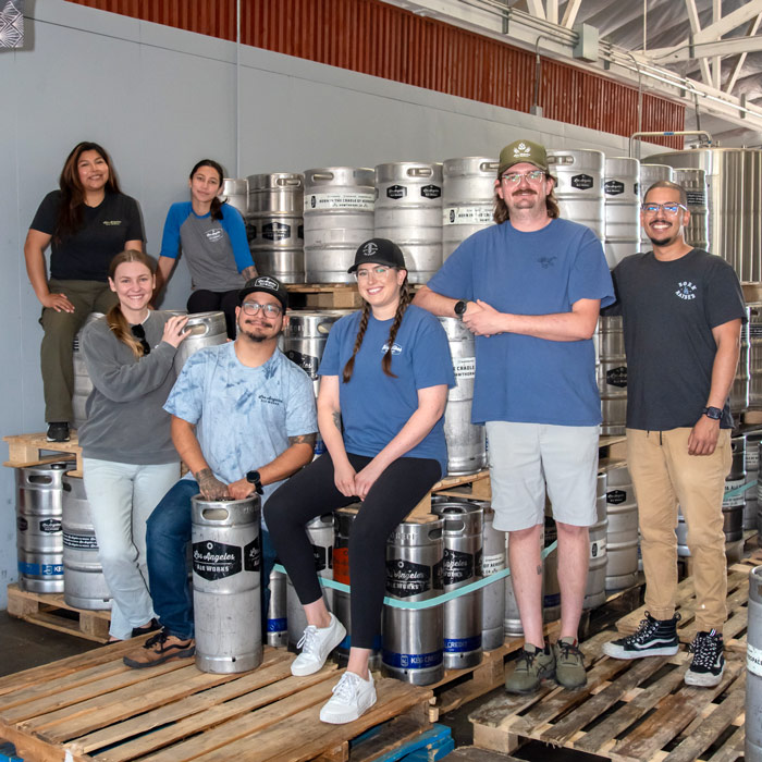 Group of Taproom staff amongst beer kegs