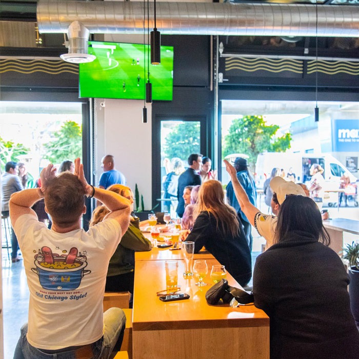 Table of people watching a soccer game on tv