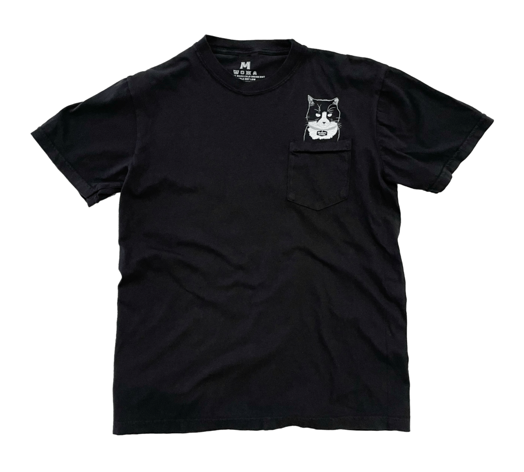 Black pocket tee with Scrappy the cat printed above pocket